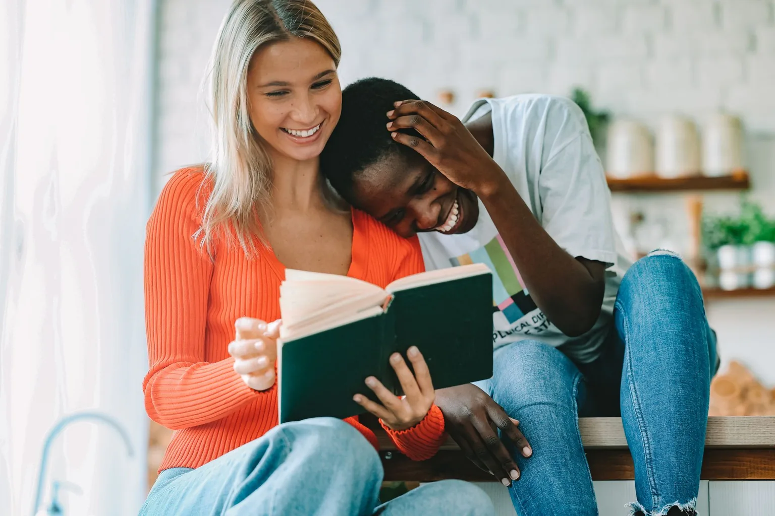 Two people reading a book together, a woman and a man in a cozy setting