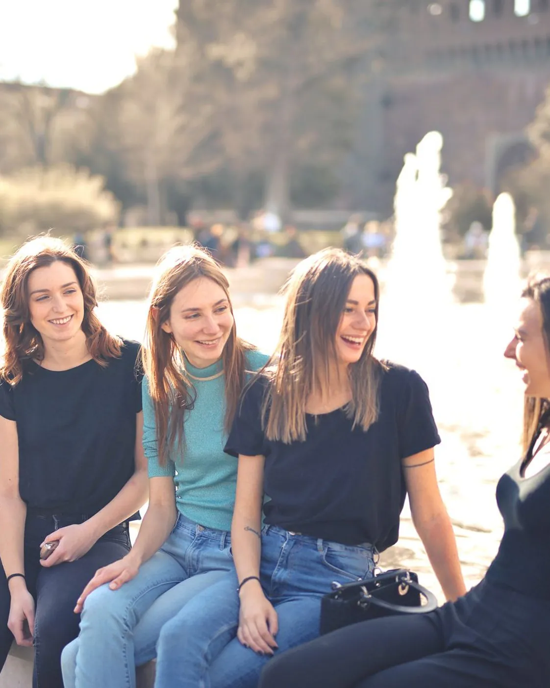Friends talking and laughing together outdoors on a sunny day